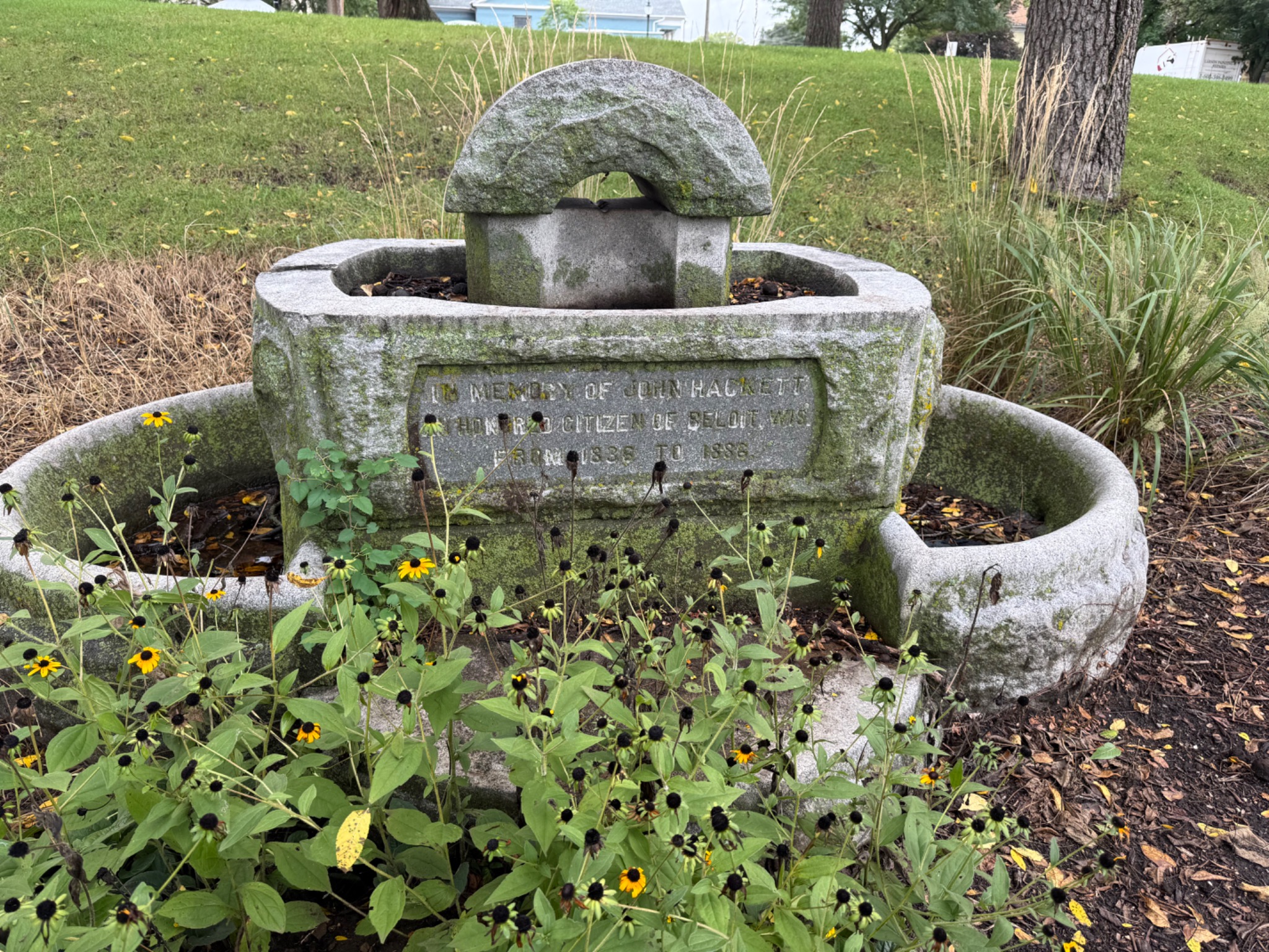 Stone John Hackett memorial horse trough among flowers in Field Park, Beloit